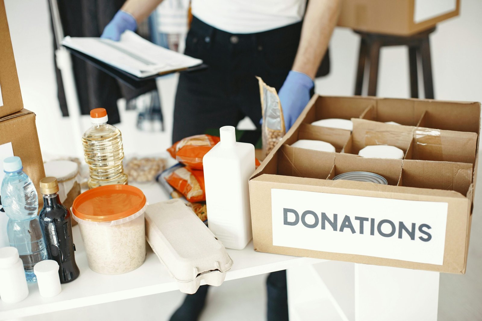 Close-up of donation box with various food items and supplies for community support.